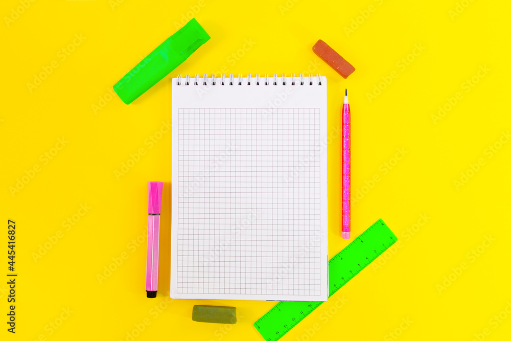 Back to school. Education. Notebook cell for notes, markers, crayons, pencil, ruler on yellow background. Flat lay. Copy space Back to school. Education. Notebook cell for notes, markers, crayons, pencil, ruler on yellow background. Flat lay. Copy space