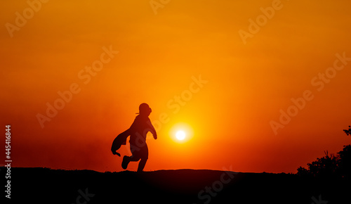 The silhouette of a superhero rushes forward with determination and determination. jogging with sun in the background, silhouette concept and evening running