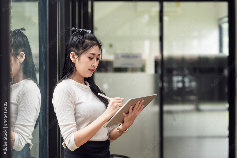Charming young Asian woman holding tablet a work concept.