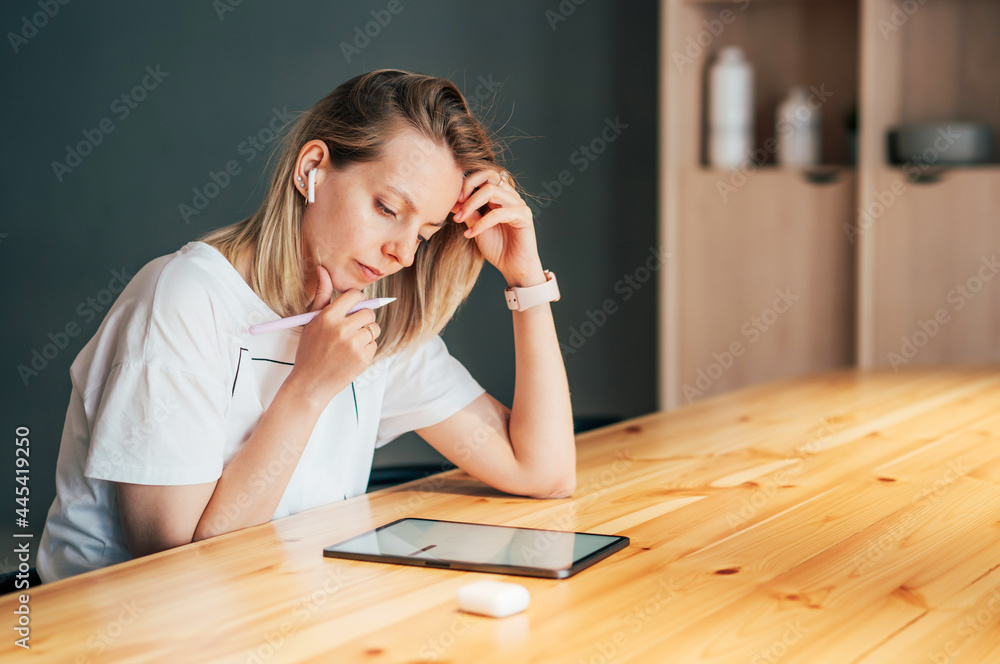 A young woman designer draws with an electronic pencil on the screen of a digital tablet A young woman designer draws with an electronic pencil on the screen of a digital tablet