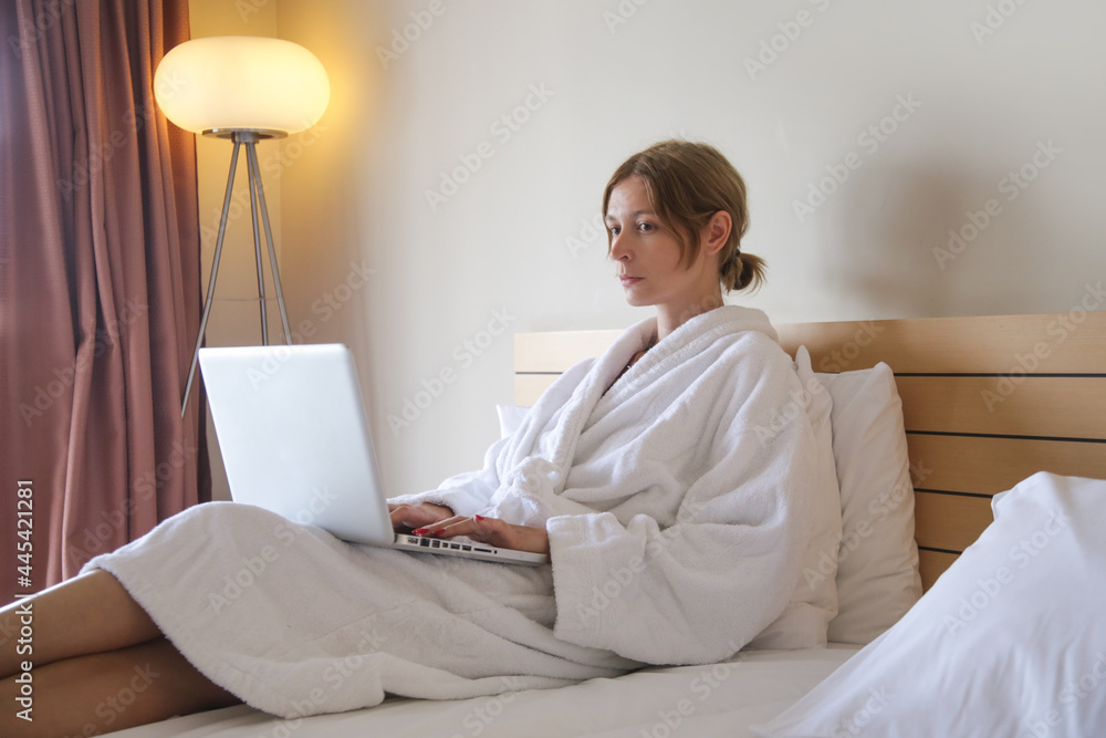 Portrait of young writer, blogger, freelancer or student sitting on the bed and working on laptop Portrait of young writer, blogger, freelancer or student sitting on the bed and working on laptop