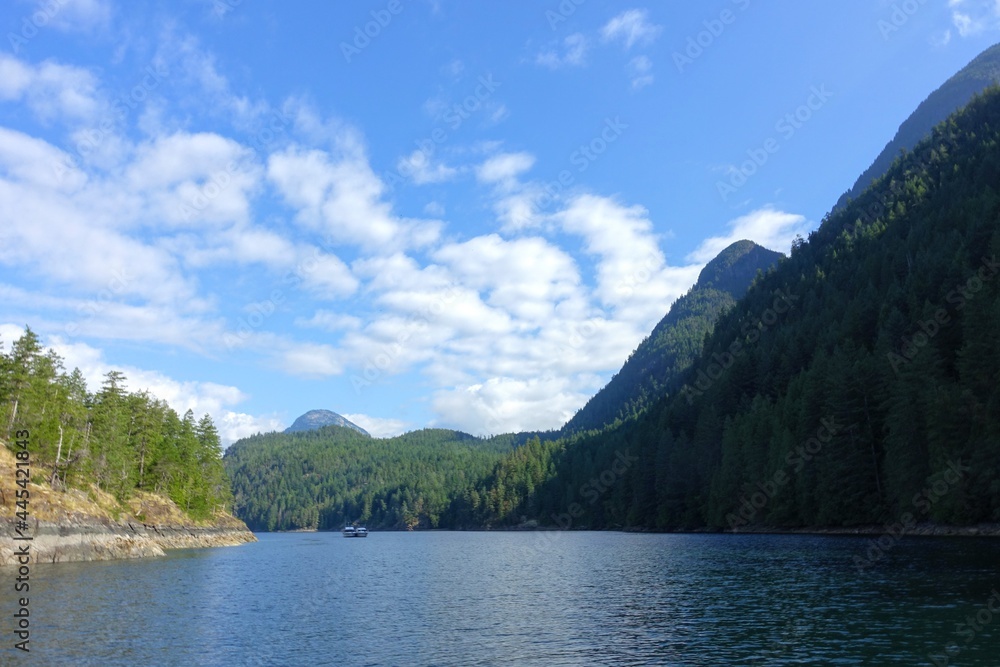 A beautiful scenic view of the harmony islands, in hotham sounds, sunshine coast, canada.  Pretty calm ocean water, forests and mountains on a beautiful sunny day