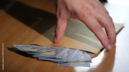 Man pick up Brown document envelope with dollar money before leave the house. Hand male hold Brown envelope on wood table. Concept travel, tourism Eating out and shopping.4K 2160p 30fps UltraHD footag