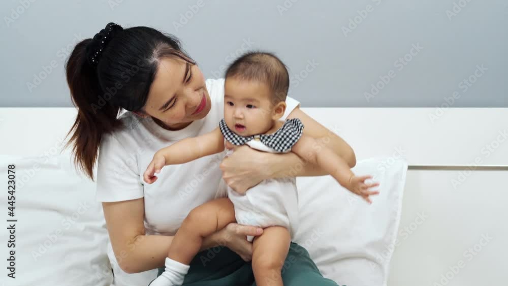 happy mother playing with baby on a bed at home happy mother playing with baby on a bed at home