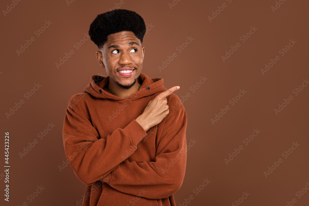 Photo of optimistic brunet hairdo young guy point empty space dress sportswear isolated on brown color background Photo of optimistic brunet hairdo young guy point empty space dress sportswear isolated on brown color background
