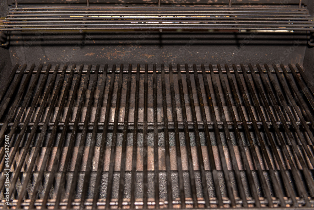 Fototapeta premium Old Empty Barbecue Grill Texture with a Thick Layer of Soot and Carbon. Dirty Iron Bbq Lattice Background Top View with Place for Text. Dark Key Photo Template for Product Advertising .