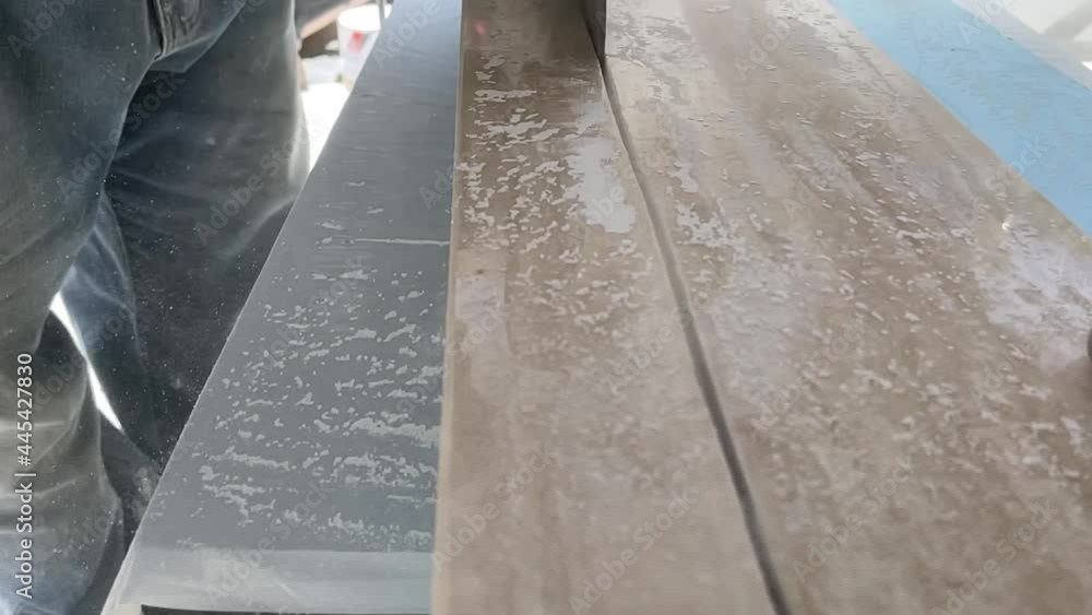 Man cuts a marble slab with the rotary saw in slowmotion Man cuts a marble slab with the rotary saw in slowmotion