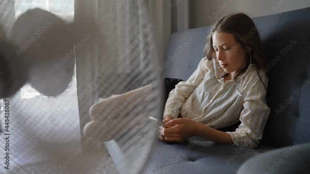 Teenager with the phone in front of cooling fan. Teenager with the phone in front of cooling fan.