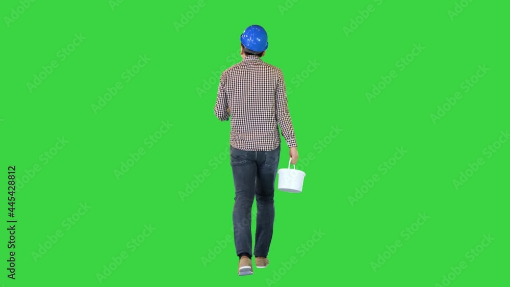Worker in hard hat with paint and brush walking and looking what to paint on a Green Screen, Chroma Key. Worker in hard hat with paint and brush walking and looking what to paint on a Green Screen, Chroma Key.