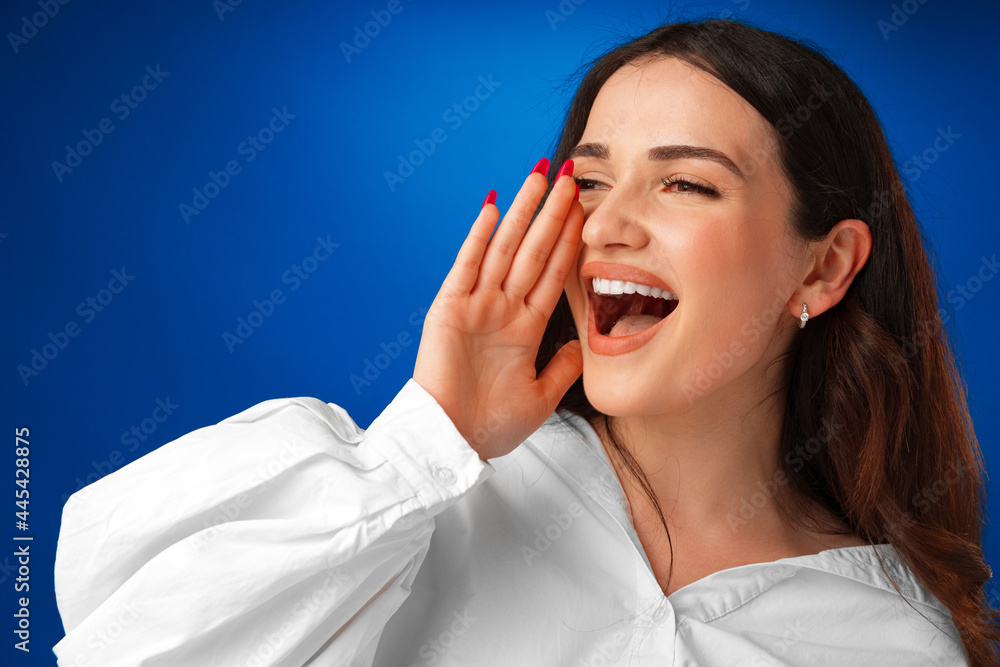 Crying emotional young woman screaming on blue studio background Crying emotional young woman screaming on blue studio background