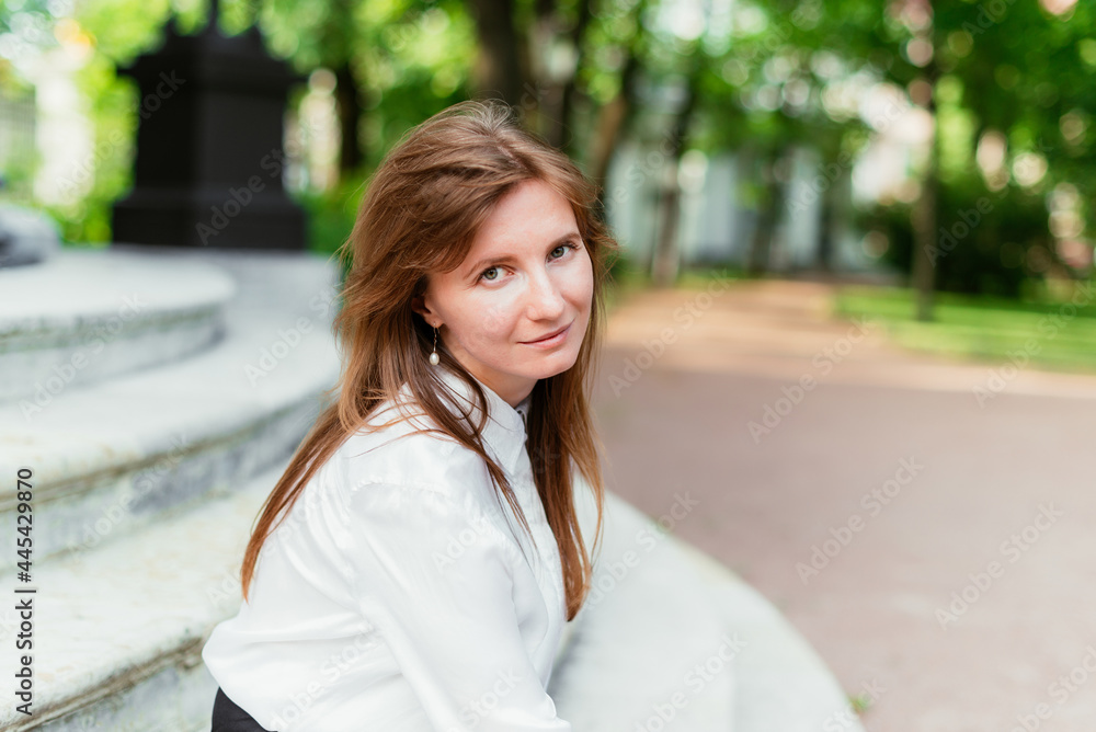 Portrait of a Caucasian girl in a summer park looking at the camera Portrait of a Caucasian girl in a summer park looking at the camera