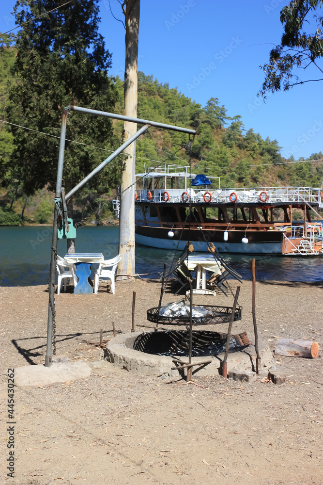 Roaster for roasting lamb meat in foil for tourists on the shores of a picturesque bay. Roaster for roasting lamb meat in foil for tourists on the shores of a picturesque bay.