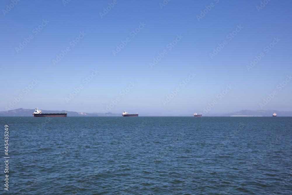 Barges on the horizon in Astoria, Oregon on a bright blue sunny sky day.