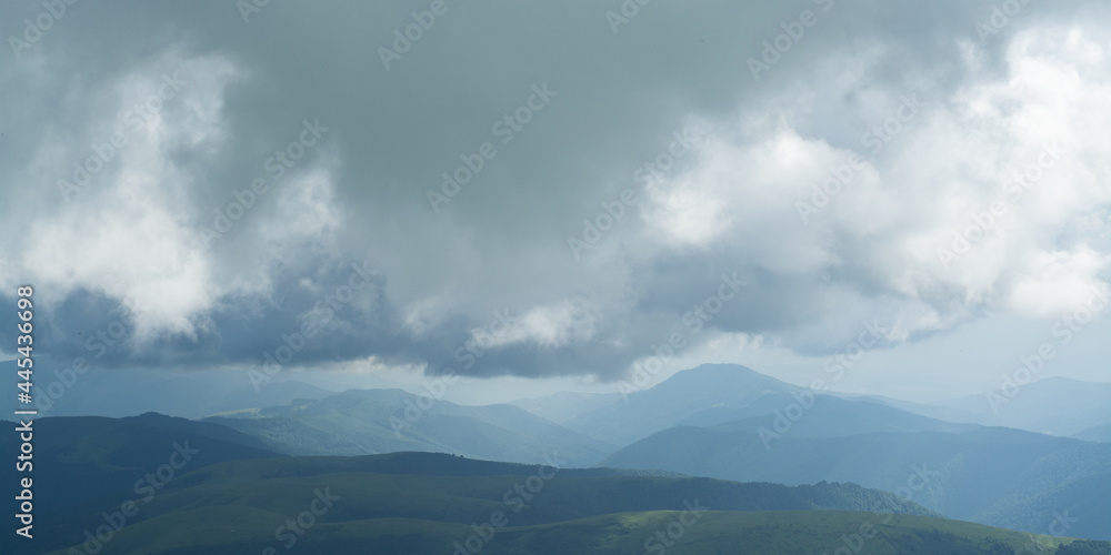 storm view from the top of mountain with distant mountains silhouettes