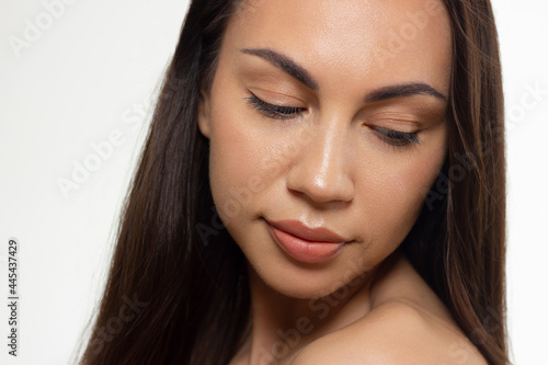 Close-up portrait of a beauty woman with full lips, straight hair and perfectly clean skin. Daytime makeup, styling and soft care. Skin care in the spa salon or cosmetology, smooth eyebrows
