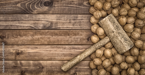 walnuts on a board together with a hammer