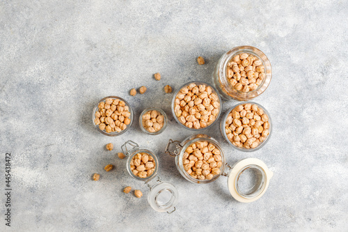 Uncooked dried chickpeas in different glass jars and bowls.