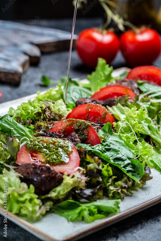 Hot salad with chicken liver, mushrooms, salad leaves, parmesan cheese and cherry tomatoes on plate. Dietary menu. vertical image. top view. place for text