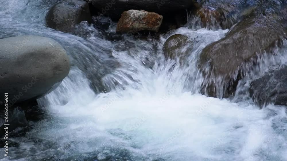 Detail shot: a river, with water running and falling over levigated rocks. Detail shot: a river, with water running and falling over levigated rocks.