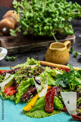 Veal salad with fresh vegetables of tomato  lettuce and parmesan cheese. Dietary food. Meat salad. Vertical image. top view