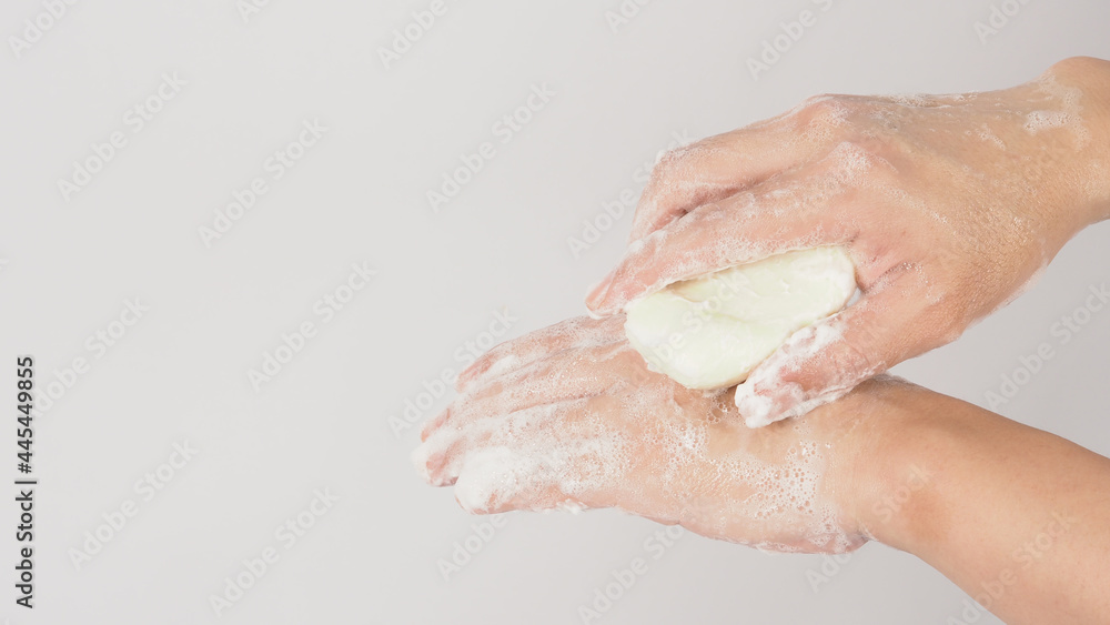 Fototapeta premium Hands washing gesture with bar soap and foam bubble on white background.