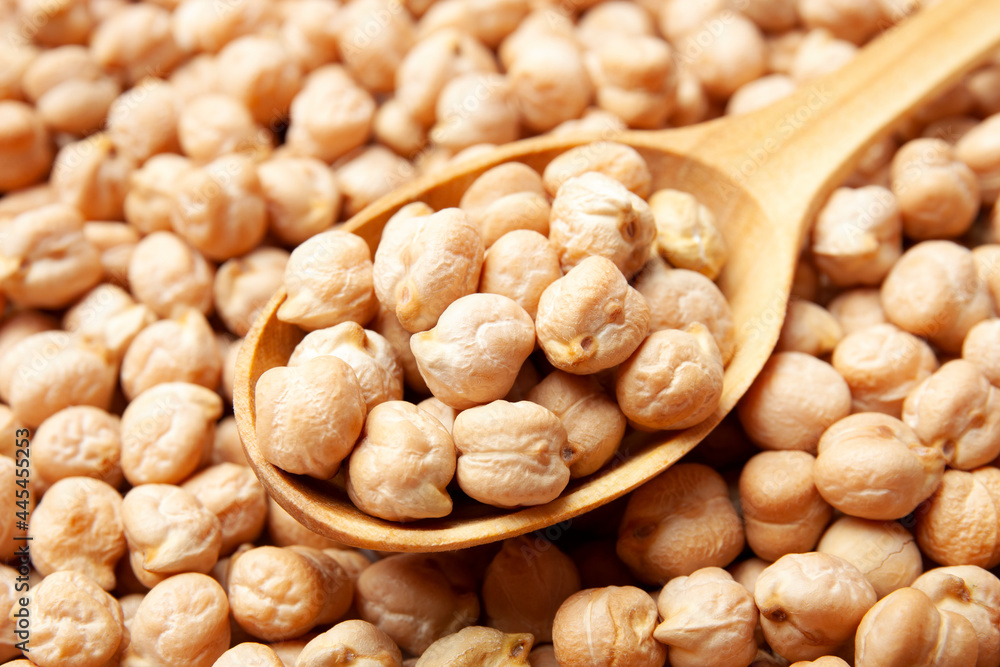 Closeup view of raw chickpea beans. Uncooked chickpeas in wooden spoon. Healthy eating Closeup view of raw chickpea beans. Uncooked chickpeas in wooden spoon. Healthy eating