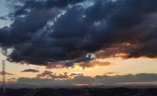 Tramonto sulle montagne e le valli dell’Appennino con grandi nuvole colorate cariche di pioggia