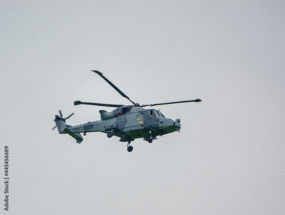 British army AgustaWestland ZZ393 AW159 Wildcat AH1 helicopter flying in a cloudy sky, Wiltshire UK