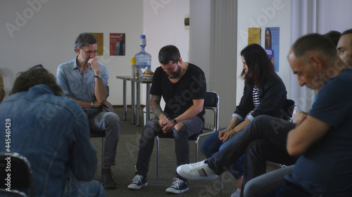 Male addict screaming in anger and crying during group meeting photo