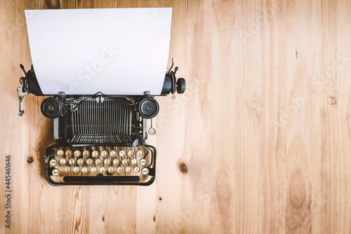 old mechanical typewriter on wooden background and blank space