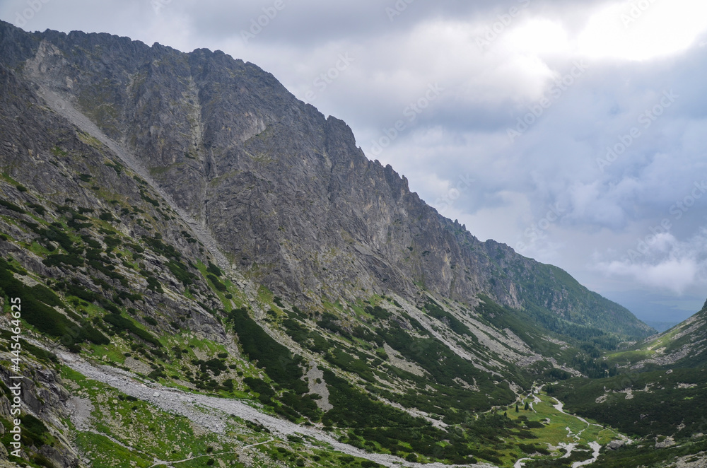 Jagged and sharp ridges rock emerge from the mist above and rain clouds at High Tatras National Park, Slovakia