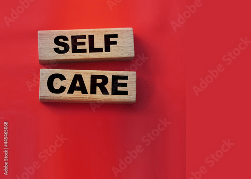 Fotografie, Obraz SELF CARE - text on wooden cubes on a red gradient background