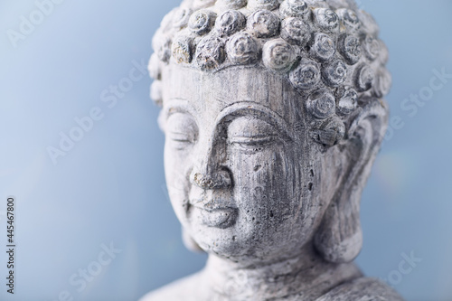 Meditating Buddha Statue on bright background. Copy space. 