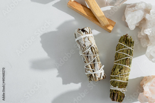 Set of incense for fumigating rooms beautifully lit by sunlight. Branches of white sage, Palo Santa sticks tied in bunch. Top view. Organic holy tree incense from America. Color photo close-up. photo
