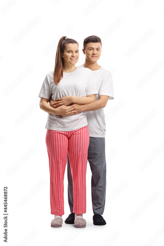 Full length portrait of a young couple in pajamas standing in embrace Full length portrait of a young couple in pajamas standing in embrace
