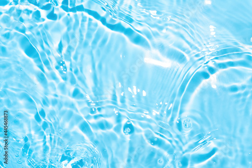 Transparent blue colored clear water surface texture with splashes. Trendy abstract nature background