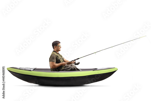 Young man catching fish and sitting in a kayak