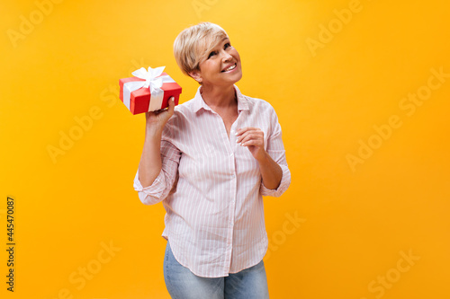 Happy lady in striped shirt posing with gift box