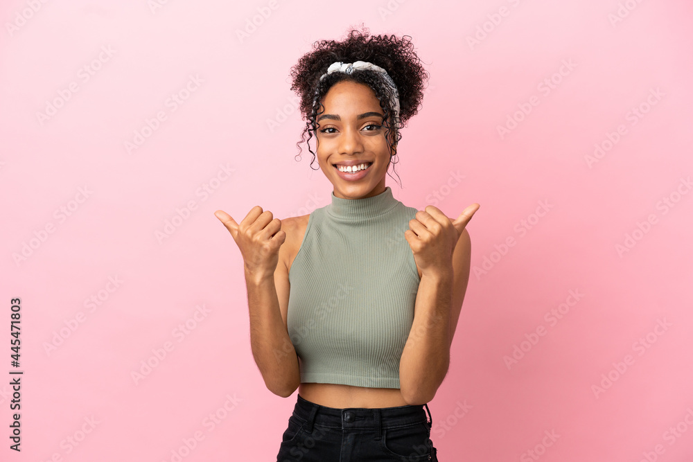 Young latin woman isolated on pink background with thumbs up gesture and smiling Young latin woman isolated on pink background with thumbs up gesture and smiling