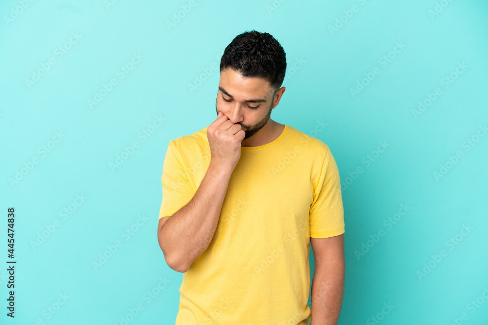 Young arab man isolated on blue background having doubts Young arab man isolated on blue background having doubts
