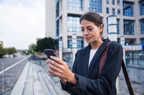 Casual young businesswoman using her smartphone
