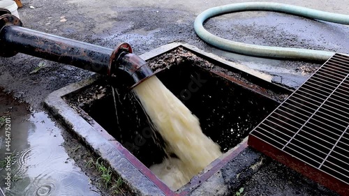 Water flows from a large pump pipe. The flooded water was pumped into the sewer. Selective focus and close up objects