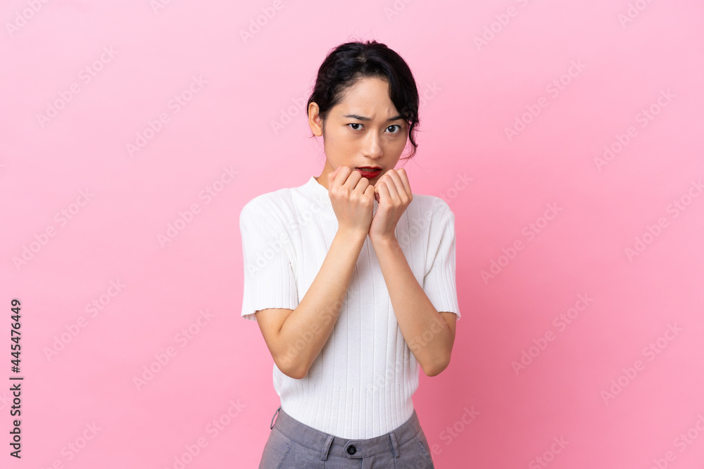 Young Vietnamese woman isolated on pink background nervous and scared putting hands to mouth Young Vietnamese woman isolated on pink background nervous and scared putting hands to mouth