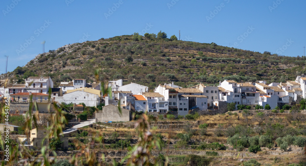 Tarbena,terraced hillside outside the town with row of characteristically whitewashed houses with terra cotta tile rooftops,