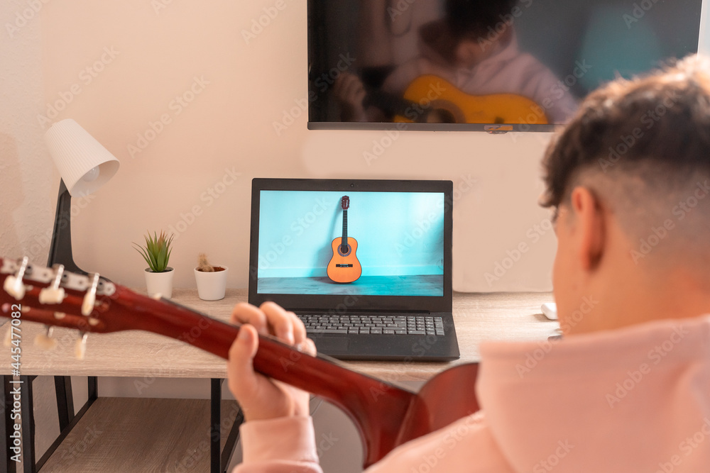 Chico tocando la guitarra en su habitación. Chico tocando la guitarra en su habitación.