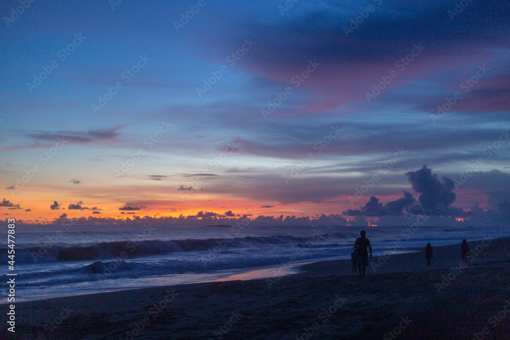 silhouettes on the beach at dusk