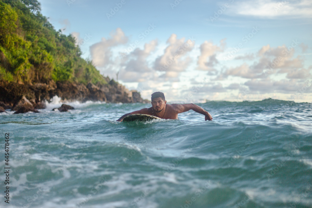 surfer swims among the waves of the sea on a summer's day