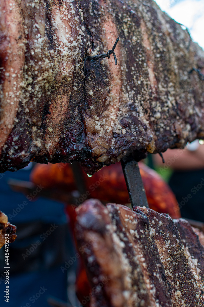 Fototapeta premium costillas de res asadas al carbón.costillas de res ahumadas.costillar de res en asador de cruz. 