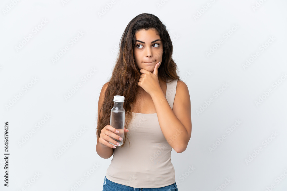 Young caucasian woman with a bottle of water isolated on white background having doubts and thinking Young caucasian woman with a bottle of water isolated on white background having doubts and thinking