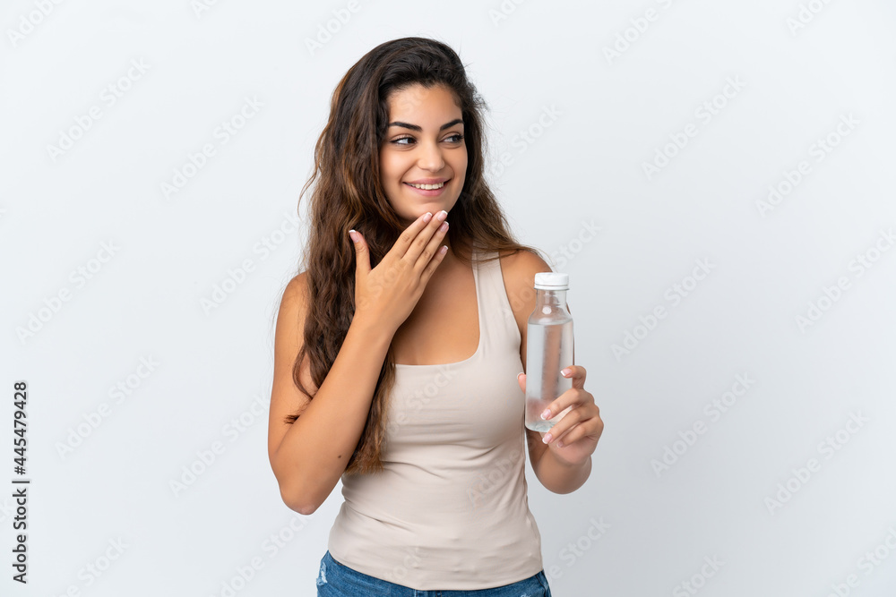 Young caucasian woman with a bottle of water isolated on white background looking up while smiling Young caucasian woman with a bottle of water isolated on white background looking up while smiling
